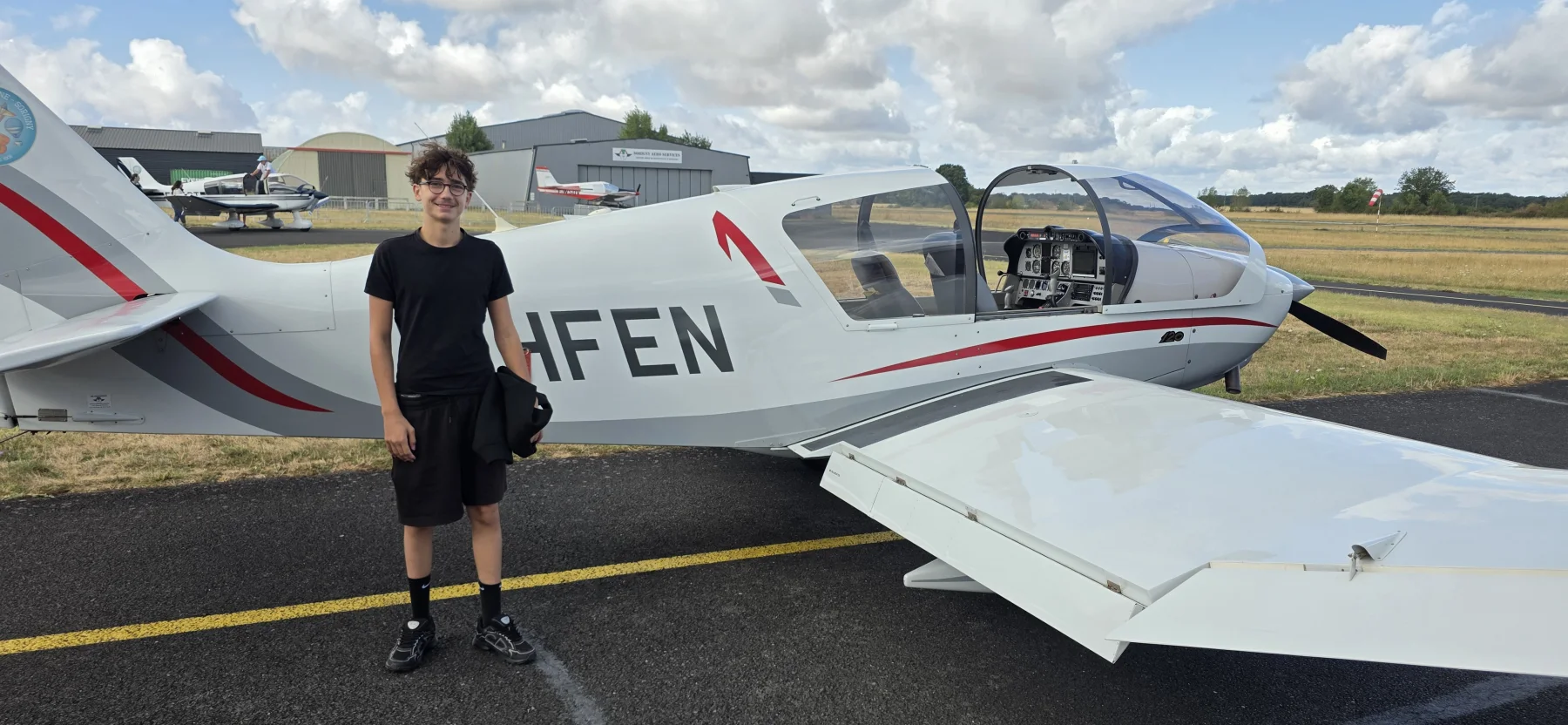 Marius Aubanelle debout devant le Robin DR401 F-HFEN blanc et rouge